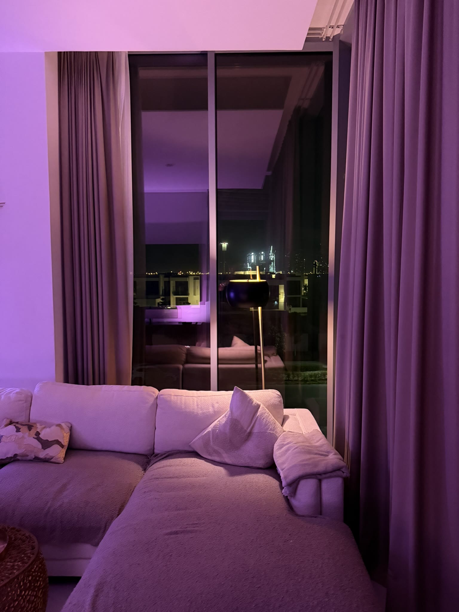 Sofa and panoramic floor-to-ceiling windows with night city view