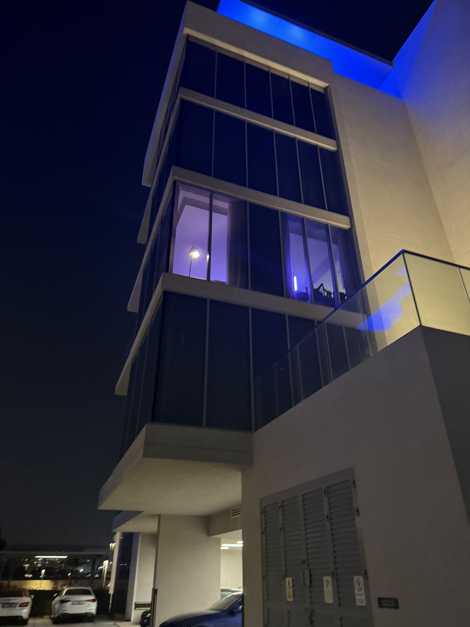 Building exterior at night with blue LED accent lighting and smart home glow