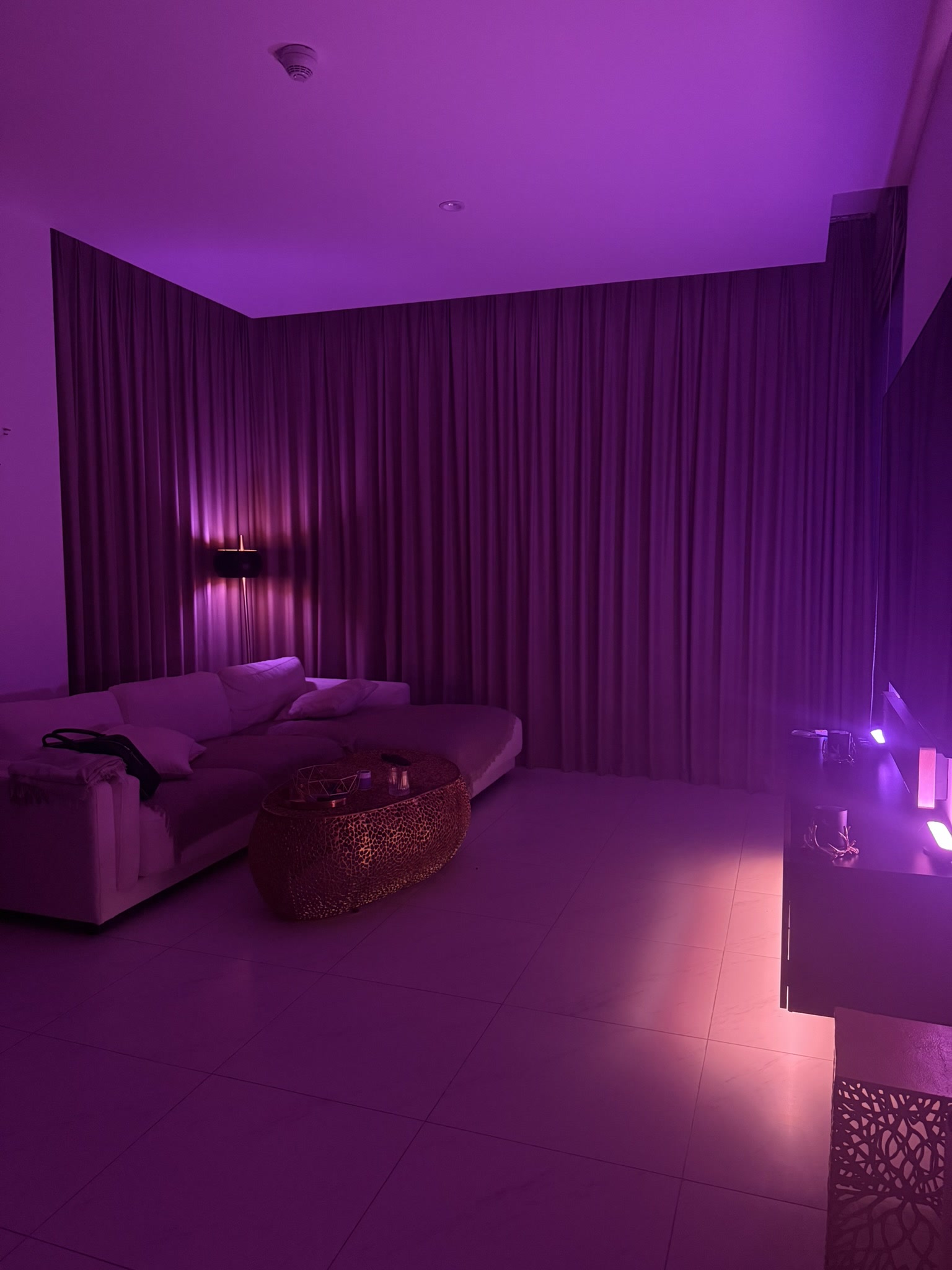 Wide living room view with purple ambient Hue lighting and smart curtains